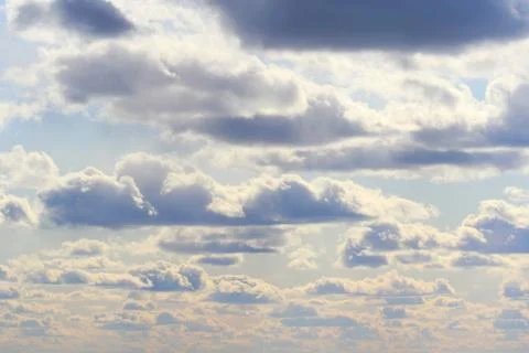 Clouds in the blue sky at sunset or dawn backlit by the sun. Place for text and Stock Photos
