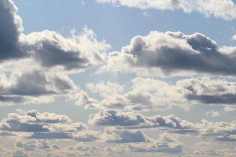 Clouds in the blue sky at sunset or dawn backlit by the sun. Place for text and Stock Photos