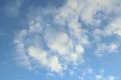 Clouds in the blue sky at sunset or dawn backlit by the sun. Place for text and Stock Photos