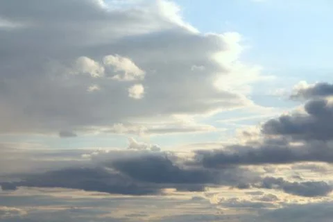 Clouds in the blue sky at sunset or dawn backlit by the sun. Place for text and Stock Photos