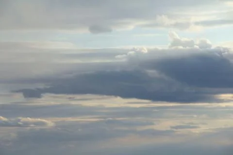 Clouds in the blue sky at sunset or dawn backlit by the sun. Place for text and Stock Photos