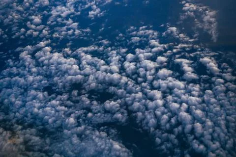 Clouds on the blue sky, top view from the window of the aircraft Stock Photos