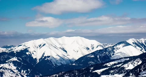 Clouds casting shadows over icy mountain range in romania borsa Stock Footage 178027793