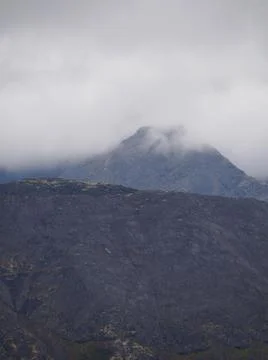 The clouds caught on the tops of the mountains. Low clouds in the mountains.  Stock Photos