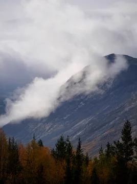 The clouds caught on the tops of the mountains. Low clouds in the mountains.  Stock Photos