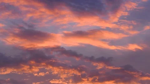 Clouds colored by the setting sun move through the evening sky Stock Footage 133647352