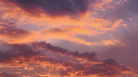 Clouds colored by the setting sun move through the evening sky Stock Footage 133686342