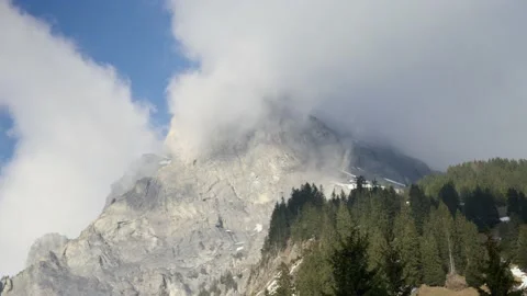 Clouds cover a huge sunny mountain in the Alps, in Switzerland Stock Footage 239731898