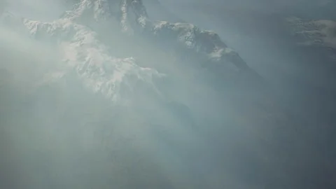 Clouds cover mountains during daytime in a remote location with soft light Stock Footage 345012389