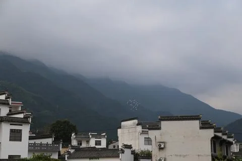 The clouds cover the mountains in front of the white buildings, and some cr.. Foto stock