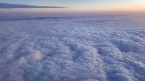 Clouds cover the sky during sunset from above the airplane Foto stock