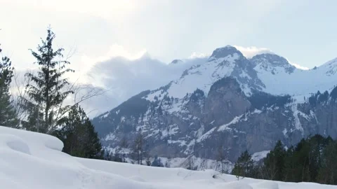 Clouds cover the snowy mountains of the Alps in winter, in Switzerland Stock Footage 239727658