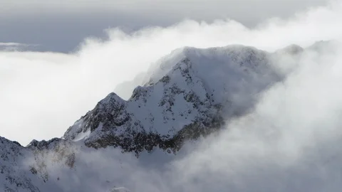 Clouds covering beautiful snow capped mountains at dusk Stock Footage 116742401