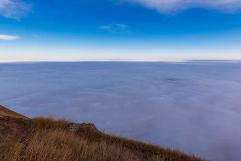 Clouds creeping below mountains Stock Photos