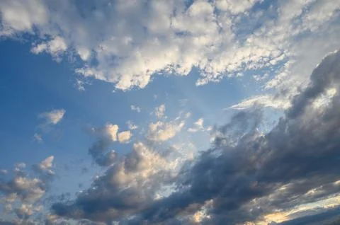 Clouds dance gracefully across a vibrant sky as the sun begins to set, pain.. Stock Photos