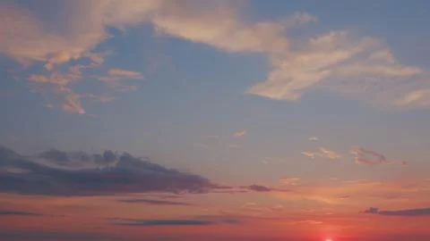 Clouds in different shades. White cirrus clouds during sunset. Timelapse. Stock Photos