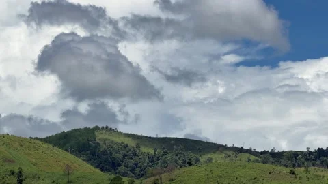 Clouds drift above green hills in a wide natural landscape. Peaceful nature. Vidéo 341408539