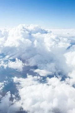 Clouds drift above a serene landscape during a clear day with blue skies and Stock Photos