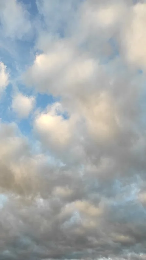 Clouds drift across the blue sky. Vertical Video Stock Footage 253892454