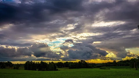 Clouds Drift Across a Heavenly Sky with Warm Glow of Sunlight Peering Vídeos de archivo 250620632