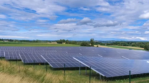 Clouds drift across a sunny sky over a solar field, a photovoltaic system Stock Footage 313787503