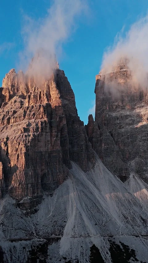 Clouds Drift Over Craggy Peaks in Sunlit Mountain Range 库存影片 334769528