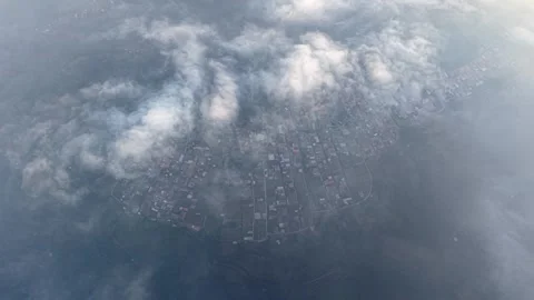 Clouds drift over a misty town below Vídeos de archivo 346913897