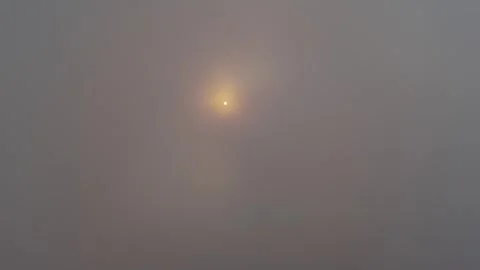 Clouds drift over the ocean at sunrise with occasional sunlight piercing th.. Stock Footage 313735398
