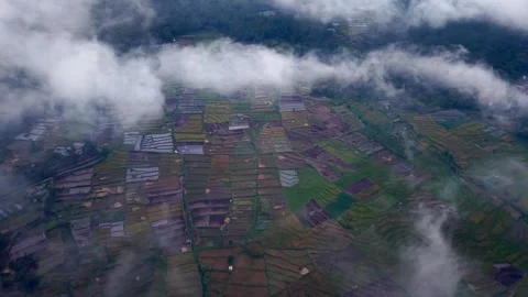 Clouds drift over patchwork farms below Stock Footage 345497133
