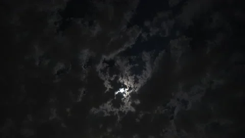 Clouds drifting across the night sky in front of the moon in this eerie Stock Footage 156734253