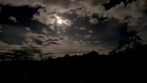 Clouds drifting on front of the almost full moon at the west Video stock 337959128
