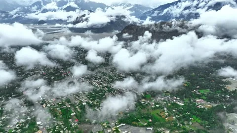 Clouds drifting over a green valley town surrounded by mountains Stock-Footage 341329011