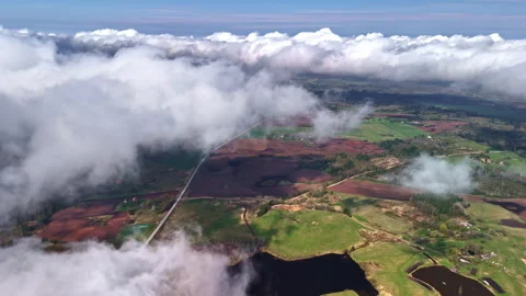 Clouds drifting over patchwork farmland and lakes Stock Footage 308766535