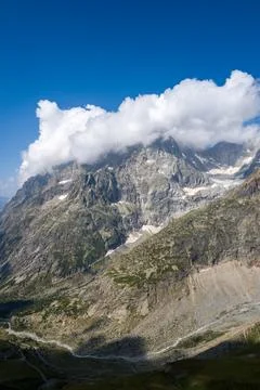 Clouds drifting over rocky alpine mountain Stock Photos