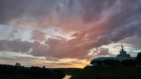 Clouds during sunset over the river and the old castle. Sunset over the city. Stock Photos