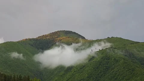 Clouds embracing green mountain during sunset Stock-Footage 315357283