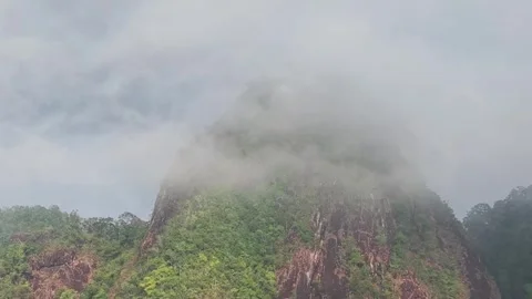 Clouds embracing lush tropical mountain peak Stock-Footage 305636796