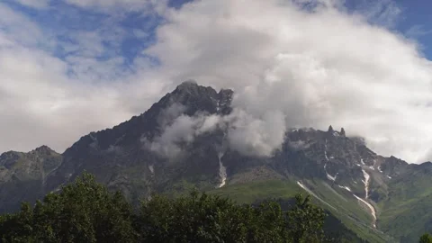 Clouds embracing mountain peak timelapse over lush valley Stock-Footage 301693814