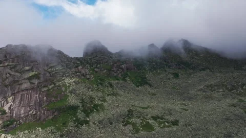 Clouds embracing mountain peaks: a breathtaking aerial view Stock Footage 300966575