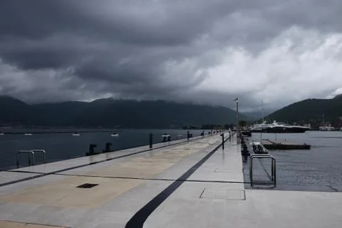 Clouds, empty pier, mountains on the background Фото