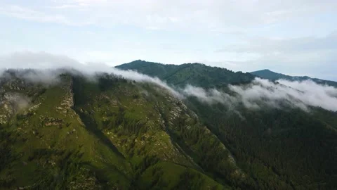 Clouds envelop the mountains in the autumn landscape. The mountain range is Stock Footage 168126710