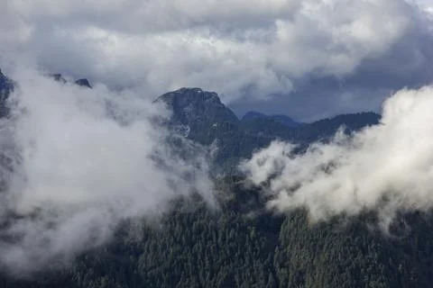 Clouds enveloping a mountain range during a dramatic weather change in the .. Stock Photos