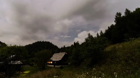 Clouds in evening sky over holiday cottage in forest mountains nature Time lapse Stock Footage 106316494