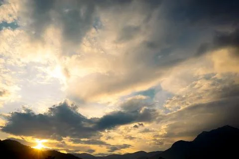 Clouds fill sky above  mountain range during sunset. colors change as dayligh Stock Photos