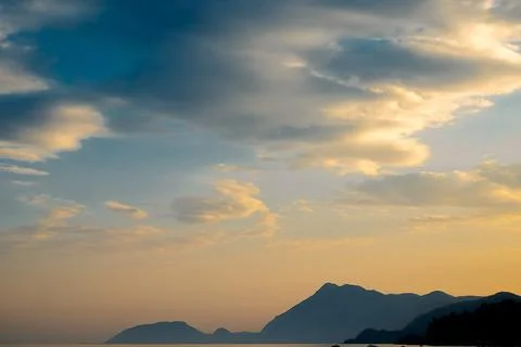 Clouds fill sky above  mountain range during sunset. colors change as dayligh Stock Photos