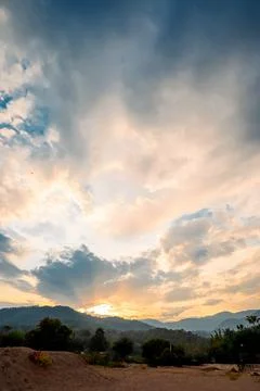 Clouds fill sky above  mountain range during sunset. colors change as dayligh Foto stock