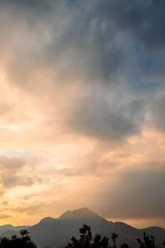 Clouds fill sky above  mountain range during sunset. colors change as dayligh Stock Photos