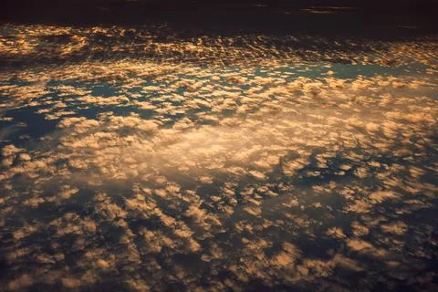 Clouds fill sky during sunset with mix of colors and patterns over horizon in Stock Photos