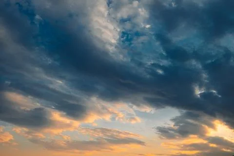 Clouds fill sky as sun sets over ocean in  coastal area. Colors change as lig Stock-Fotos