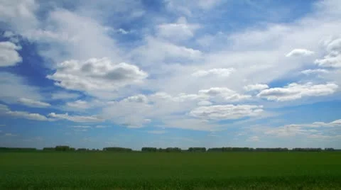 Clouds float above the green field. Stock Footage 12528815
